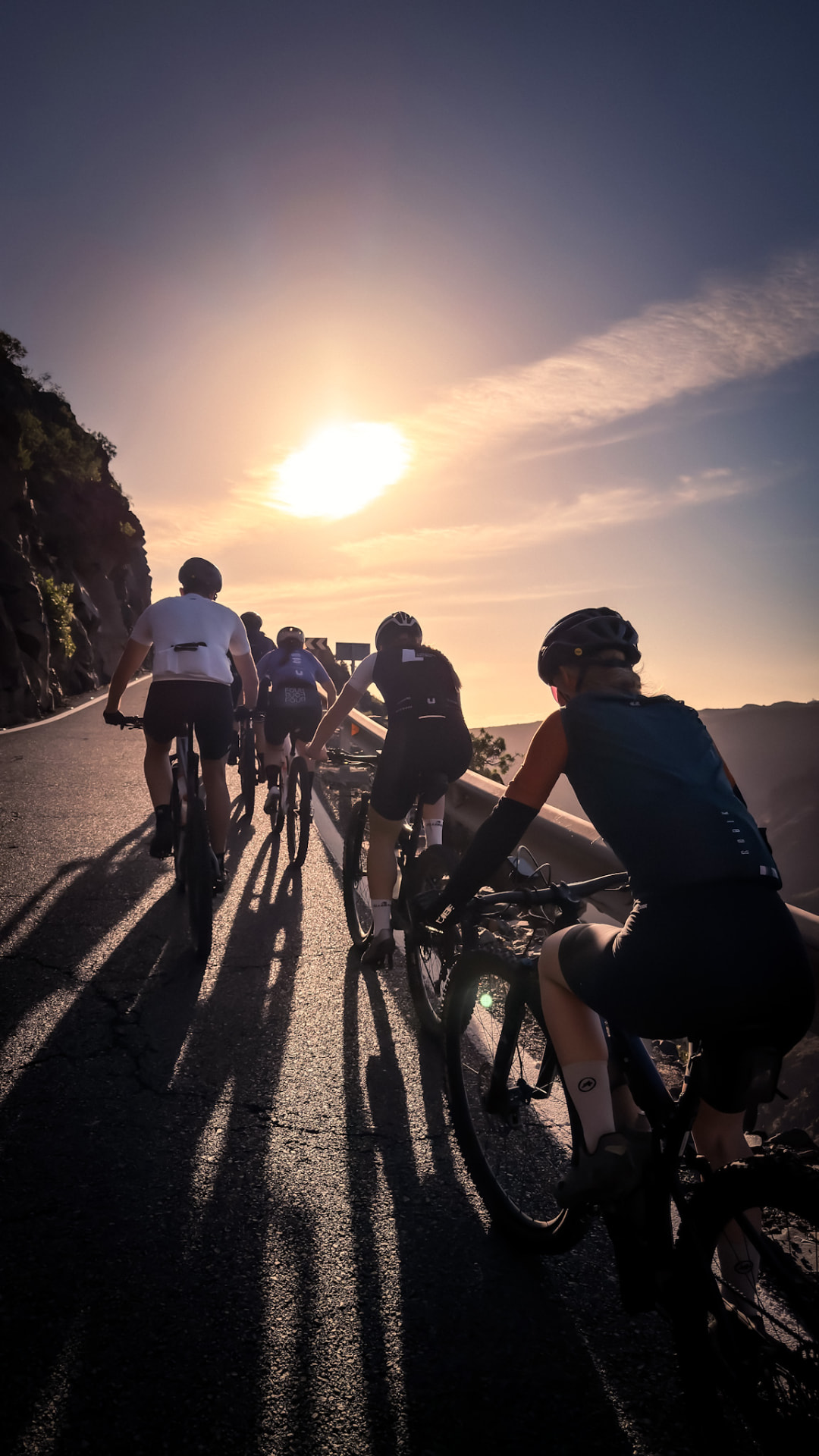 Cyklister på väg uppför ett berg i solnedgång